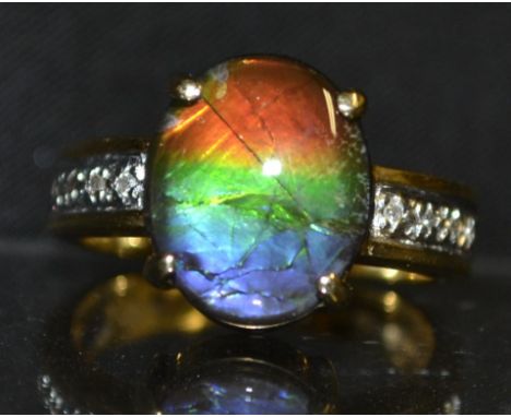 A black opal doublet and diamond ring, oval opal panel, flashing green, red, orange and purple colour play, tapering two tone