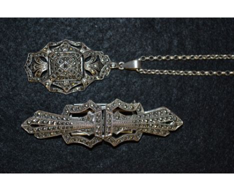 An Art Deco silver and marcasite three section clip brooch, each side with open tapering platform and cresting terminal, stam
