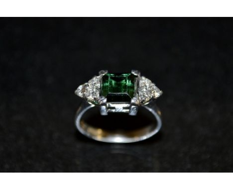 An Art Deco style emerald and diamond and white sapphire ring, central rectangular deep green emerald, flanked to either side