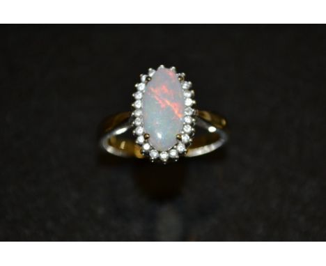 An opal doublet and diamond ring, central oval opal doublet, flashing red, green, blue and violet colour play, above a band o