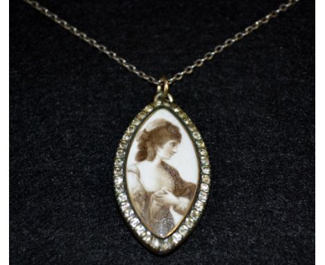 A Georgian gold coloured metal paste stone set mourning pendant, inset with a painted Navette shaped sepia portrait miniature