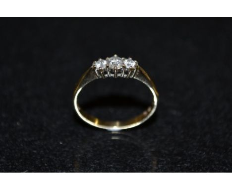 A diamond trilogy ring, central round cut diamond flanked by two smaller conforming, total diamond weight approx 0.25ct, 9ct 