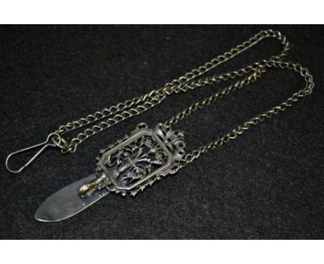 A Continental silver coloured metal Chatelaine, rectangular floral top panel with hinged slide clip, suspending a double tria