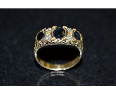 A diamond and sapphire seven stone ring, central oval dark blue/black sapphire, flanked by two smaller conforming, one to eac