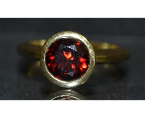 A 14ct gold and red garnet solitaire ring, rub over collet, size R, stamped 585ABS, 8.5g gross