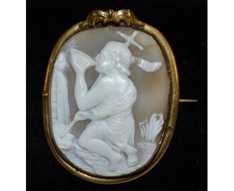 A 19th century Victorian carved shell cameo brooch, irregular rounded panel carved with a kneeling figure taking Libation ben