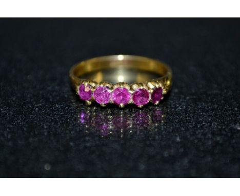 A ruby and red spinel five stone ring, set with five round cut pinky red rubys and spinels, 18ct gold shank, stamped 18ct, si