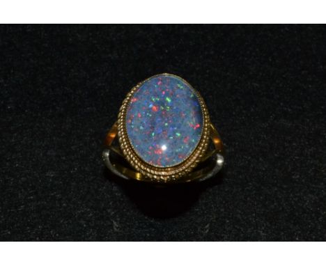 A black opal doublet ring, oval black opal doublet, rope twist surround, 9ct gold shank, stamped F&RB, 375, Birmingham 1976, 