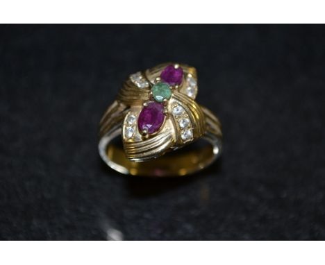 A multi colour paste diamond emerald and ruby effect dress ring, sinuous crown inset with thirteen assorted stones, 14 ct gol