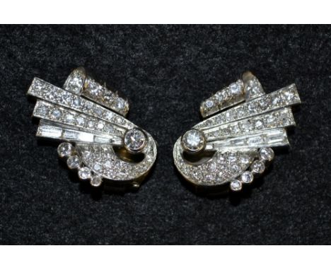 A pair of Art Deco diamond encrusted fan earrings, each multi layered fan crests pave encrusted with forty one round and bagu