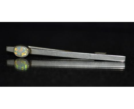 An early 20th century silver and opal tie pin, single oval opal flashing green ,blue and orange colour play, unmarked silver 