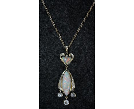 A black opal and diamond pendant necklace, heart shaped top suspending an oval droplet, set with a central opal between taper