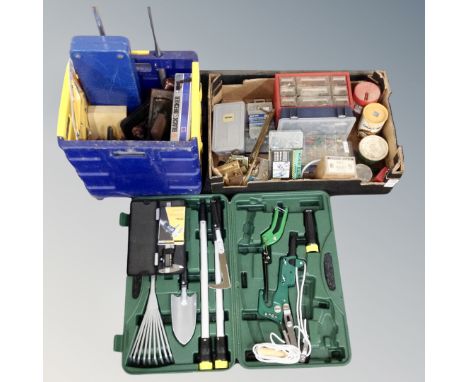 A plastic crate containing tools, hand tools, a box of hardware, screws, a plastic box containing a gardening toolkit.