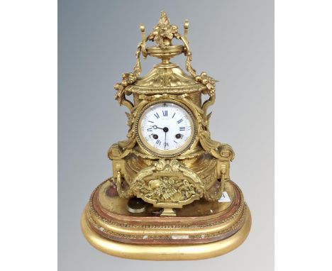A 19th century French gilt metal mantel clock with enamelled dial, retailed by J. Silvant of Paris, on gilt stand, clock heig