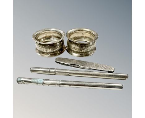 A pair of silver napkin rings together with two thermometer cases and a silver pen knife.