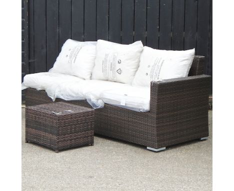 A brown rattan three seater garden sofa, 200cm, with loose cushions, together with a matching coffee table