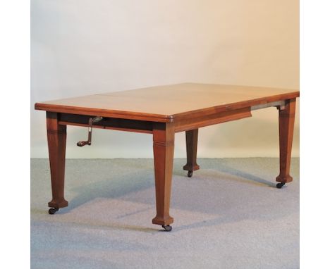 An Edwardian light oak wind-out extending dining table, with an additional leaf, 180 x 104cm and table winder