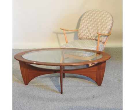 An Ercol light elm stick back open armchair, with loose cushions, together with a teak oval coffee table, with an inset glass