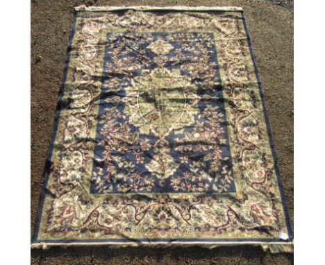 A Tabriz design machine made carpet, the indigo field with a central lobed pole medallion, within an ivory scrolling leaf and