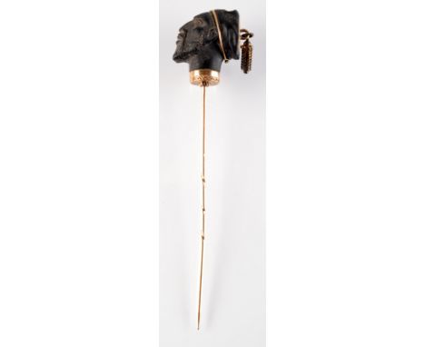 A fine 19th century pin, the finial a Blackmoor head with gold tassel, cased.