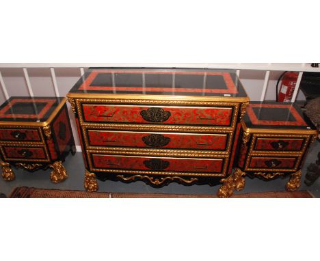 A lavish ebonised and carved gilt commode of three long drawers with gold painted red ground panels width 119cm, together wit