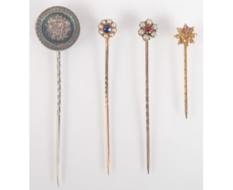 A gold flower head stick pin, a silver Victorian flower engraved pin and two pearl cluster finial pins, one with a ruby, the 