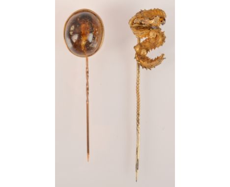 A pin, the finial with a fly trapped in resin together with a Chinese gold dragon pin.