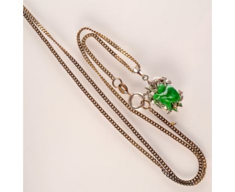 A platinum pendant set with carved jade and diamonds on a silver chain.