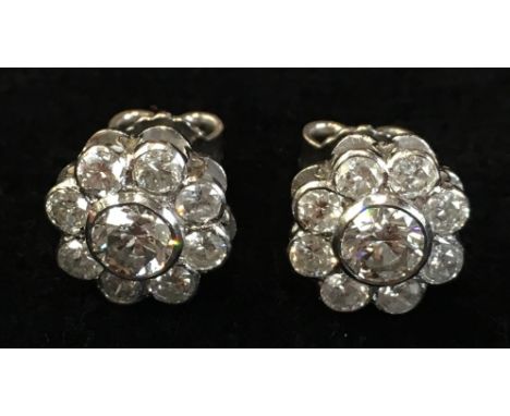 A pair of good diamond and platinum cluster earrings, each with a central stone of approximately .25ct. spread within a circl