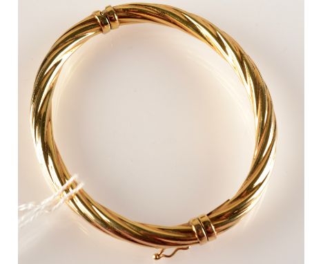 A contemporary 9ct. gold spiral fluted hinged bangle, 10g.   Condition Report: Hinge and spring good, bangle very good condit