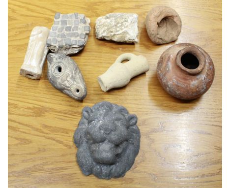 Selection of roman artifacts, including ceramic lion head, ornate oil lamp, small clay jug etc.