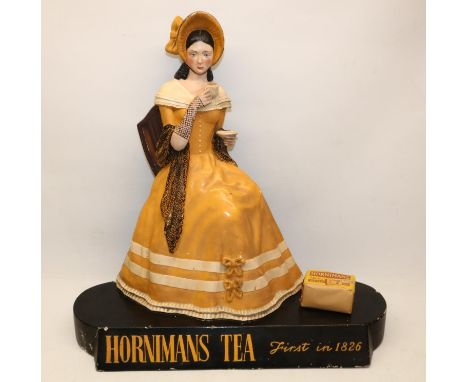 Mid 20th century Hornimans Tea composition advertising sign, modelled as a lady wearing a bonnet and holding a cup of tea, ra