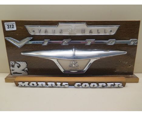 Four Vauxhall badges and a Morris Cooper badge 
