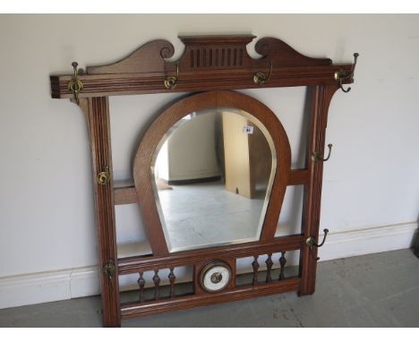 An early 20th century oak framed wall mirror and coat / hat rack with small barometer, 94cm tall x 97cm 