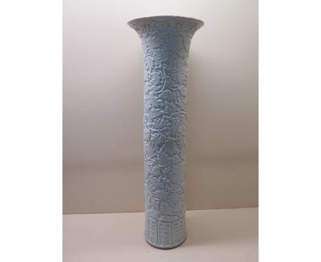 A Chinese early 20th century arrow vase with carved decoration of lotus panels and chrysanthemum under a blue and white glaze