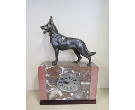 An Art Deco marble mantle clock surmounted by a speltar Alsatian dog - 49cm tall, running, some small chips 