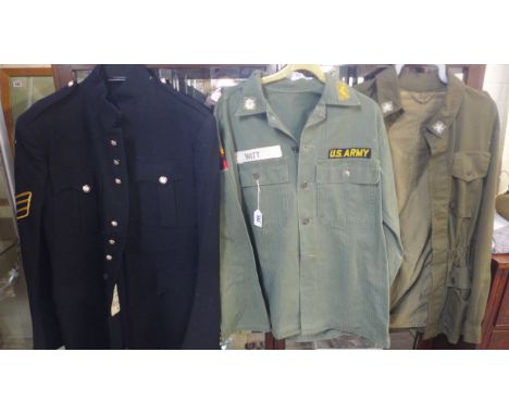 A US Army style military shirt with cloth badges, together with two other military style shirts, together with an associated 