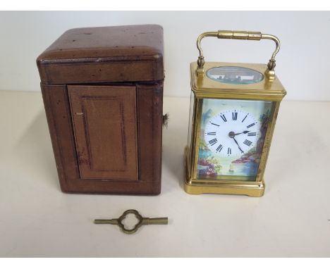 A French 8 day brass carriage clock with hour and half hour strike, the enamel dial painted with a water scene with boat, bir