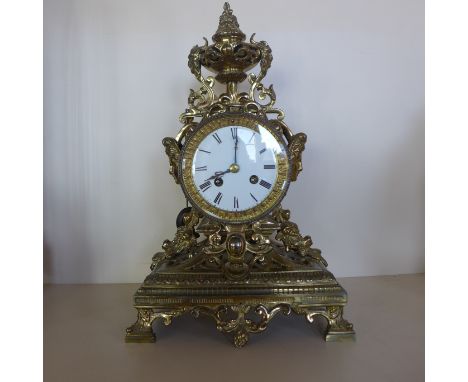 A 19th century French mantle clock in a good quality ornate brass case, striking on a bell, in good condition with a pendulum