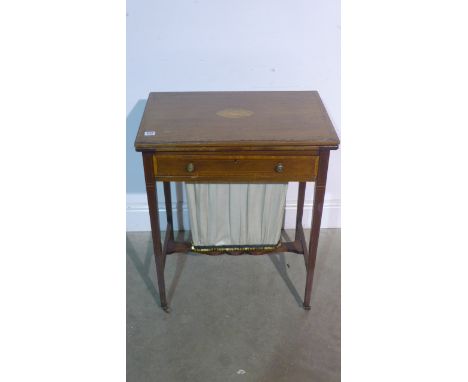 An Edwardian mahogany inlaid fold over card table and work box with a fitted drawer above a sliding work box raised on taperi