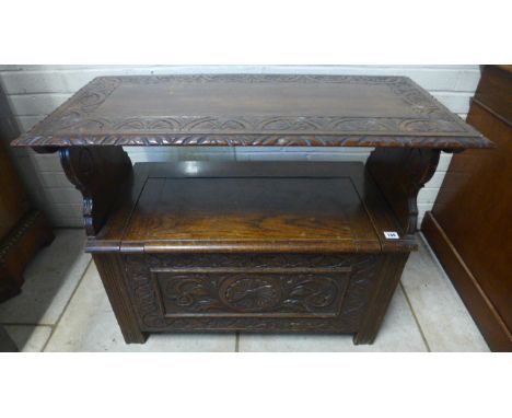 A 1930s carved oak hall/monks bench with a lift up seat - 80cm wide 