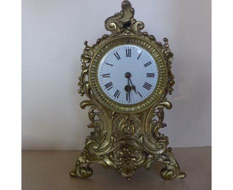 A 19th century French ornate brass mantle clock, 29cm high, in good condition with a pendulum 