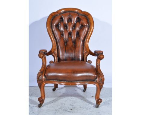 A walnut framed gentleman's balloon back armchair, re-upholstered in nailed brown leather button back, scrolling carved arms 