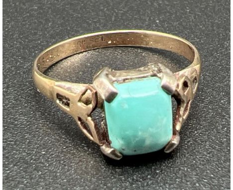 A vintage 9ct gold and turquoise dress ring with a silver stone mount. Square shaped cabochon of turquoise with a pierced fol