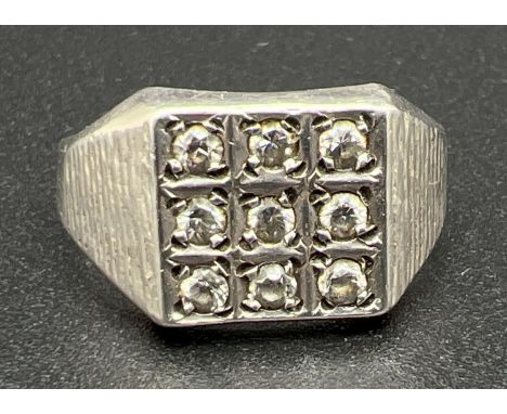 A men's vintage silver and clear stone set ring with textured effect shoulders. Band slightly misshapen on one side. Stamped 