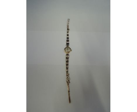 A ladies 9ct gold wrist watch by Rotary having a baton numeral dial on a graduated knife blade bar bracelet