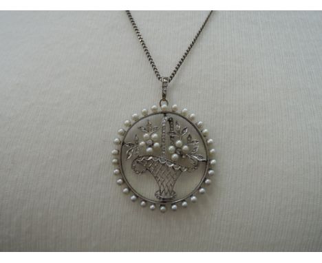 A Victorian style pearl and diamond pendant modelled as a basket of flowers (one pearl and diamond missing) on a white metal 