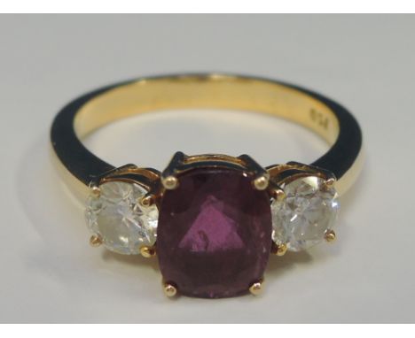 A ladies dress ring having an oval ruby, approx 1.75ct flanked by two diamonds, each approx .5ct in a raised claw setting on 