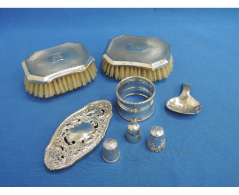 A selection of HM silver including thimbles, napkin ring, clothes brushes, caddy spoon etc