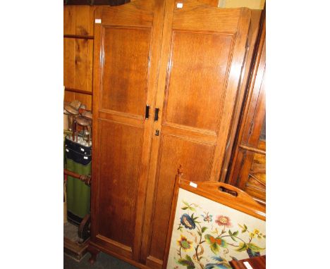 A 1920's oak wardrobe having double panel doors on cabriole legs